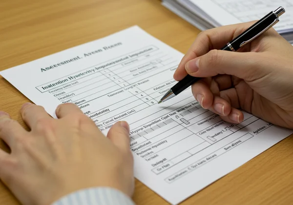 Parent or teacher filling out a Vanderbilt assessment form